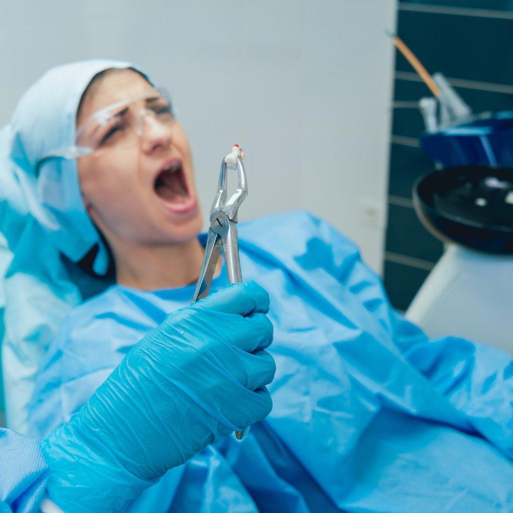 Nervous patient eyeing a dentist's extraction forceps