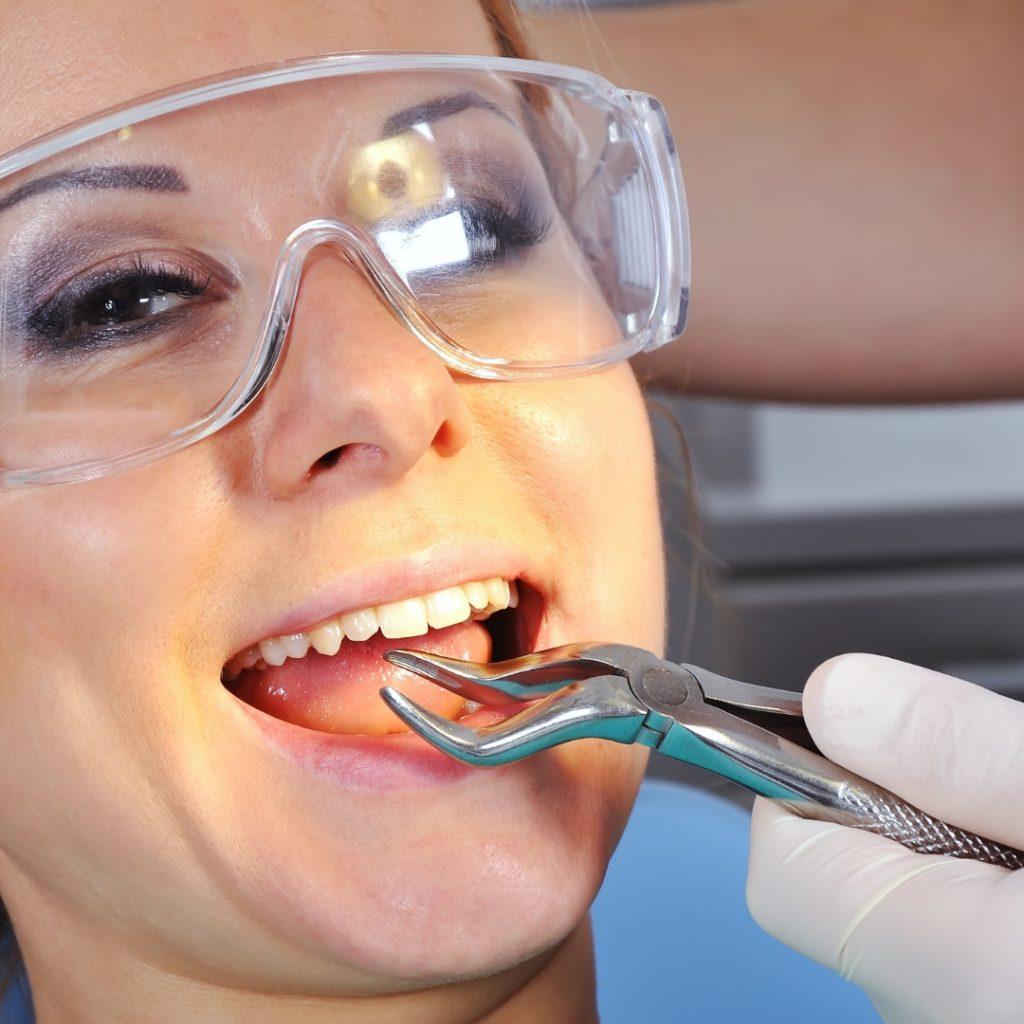 Patient in safety glasses having a tooth removed