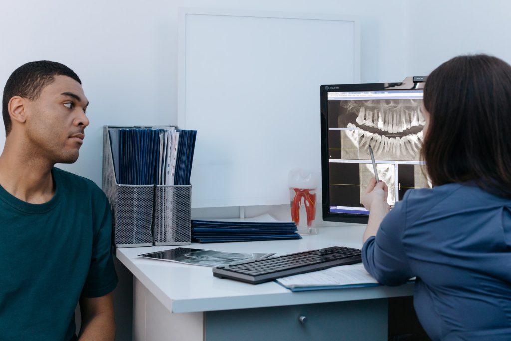 Patient reviewing digital dental X-rays with a dentist